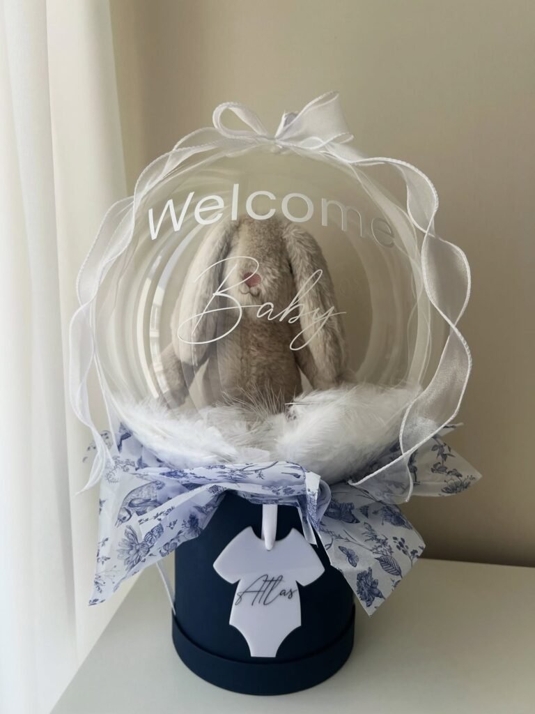 "Welcome Baby" yazılı bobo balonda peluş tavşan ve beyaz tüyler, zıbın isimlikli lacivert erkek bebek balon kutusu