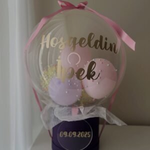 Altın "Hosgeldin" yazılı bobo balonda pembe, lila ve sarı balonlar, köpük toplar; mor kutulu pastel yenidoğan balon kutusu